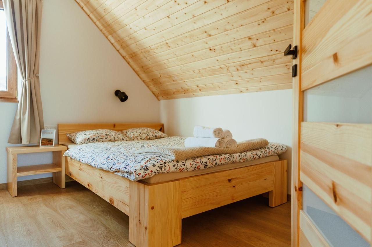 Łóżko pod drewnianym skosem dachu